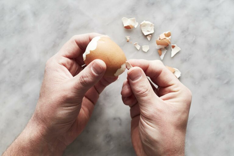 person peeling eggs
